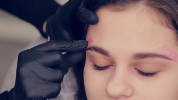 Professionnel maître sourcil femme faire épilation avec cire sourcil à client à client dans salon de beauté . — Video