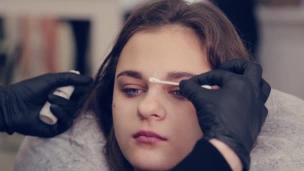 Professionell kvinna ögonbryn mästare hanterar en bomulls knopp med ögonbryn till kund i skönhetssalong. — Stockvideo