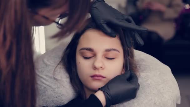 Professionelle Meisterin Augenbrauen Frau kämmt Augenbrauen zu Client in einem Schönheitssalon. — Stockvideo
