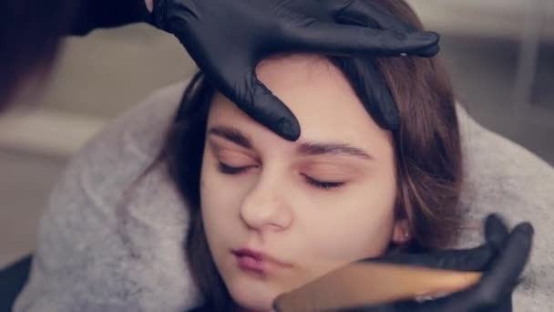 Professionell mästare ögonbrynskvinna drar ögonbryn till klienten i en skönhetssalong. — Stockvideo