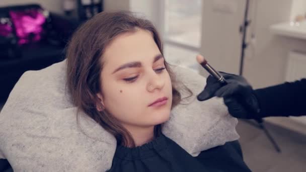 Profesional maestro de cejas mujer dibuja las cejas al cliente en un salón de belleza . — Vídeos de Stock
