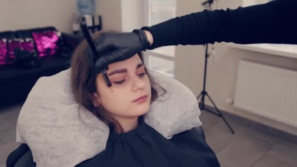 Professionell mästare ögonbrynskvinna drar ögonbryn till klienten i en skönhetssalong. — Stockvideo