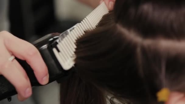 ヘアクリップでクライアントに髪を切断プロの美容師の女性. — ストック動画