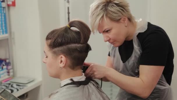 Parrucchiere professionista donna taglio capelli al cliente con tagliacapelli . — Video Stock