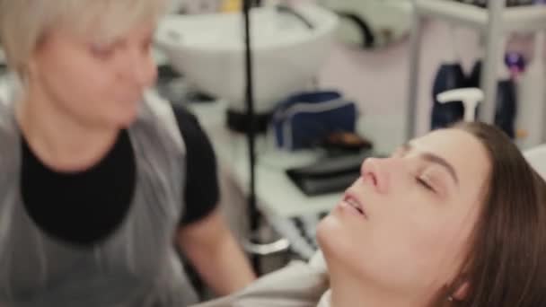 Professional hairdresser woman washes hair to client. — 비디오