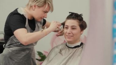 Profesyonel kuaför kadın müşteriye ıslak saç stili yapıyor..