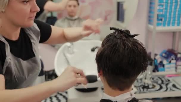 Professional hairdresser woman doing hairstyle on wet hair to client. — 비디오