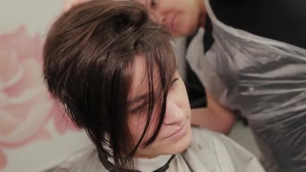 Professionele kapper vrouw doet kapsel op nat haar klant. — Stockvideo