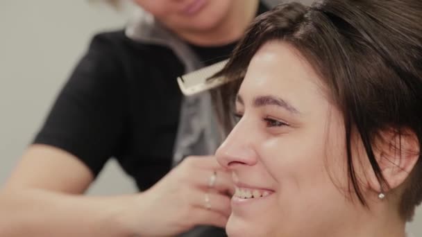 Επαγγελματική κομμώτρια γυναίκα κάνει χτένισμα σε βρεγμένα μαλλιά στην πελάτισσα. — Αρχείο Βίντεο