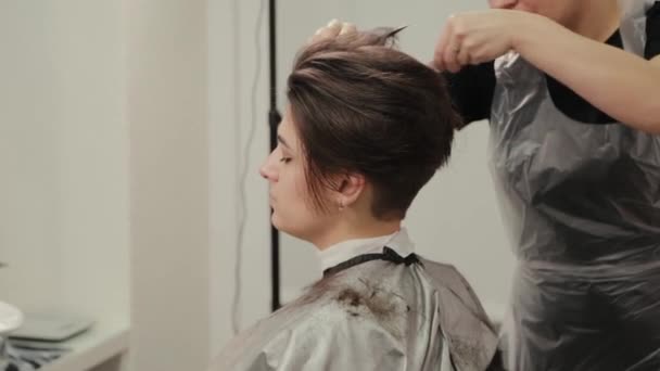 Professionell frisör kvinna gör frisyr på vått hår till kund. — Stockvideo
