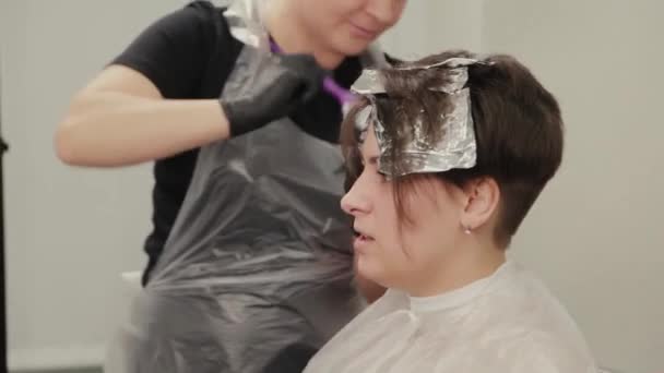 Peluquería profesional mujer tintes niñas cabello con tinte de pelo en papel de aluminio . — Vídeos de Stock