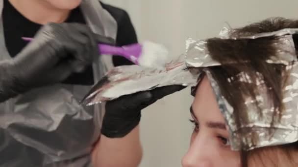 Peluquería profesional mujer tintes niñas cabello con tinte de pelo en papel de aluminio . — Vídeos de Stock