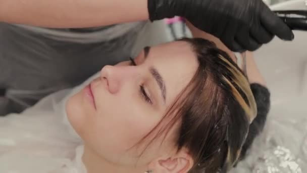 Profesyonel kuaför kadın saç boyacısı kızı yıkıyor.. — Stok video
