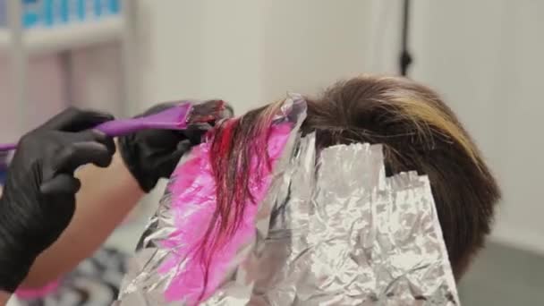 プロの美容師の女性は髪染めの女の子を洗う. — ストック動画