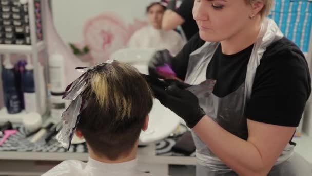 Professional hairdresser woman washes hair dye girl. — 비디오