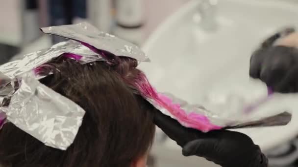 Professional hairdresser woman washes hair dye girl. — Stock Video