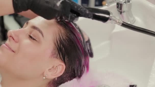Profesionální kadeřnice žena myje vlasy barvení na klienta po barvení.