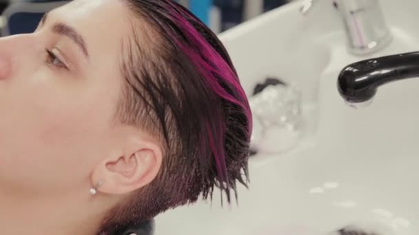 Peluquería profesional mujer lava el tinte para el cabello al cliente después de teñir . — Vídeo de stock