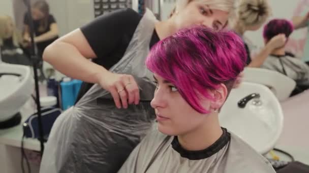 プロの美容師の女性のスタイリングの女の子は髪を染色した後. — ストック動画