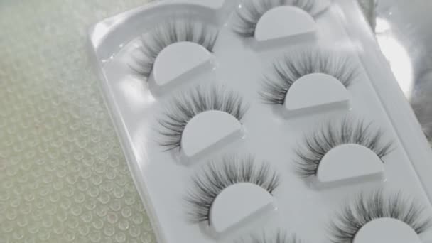 False eyelashes in a package on a table by a makeup artist. — 비디오