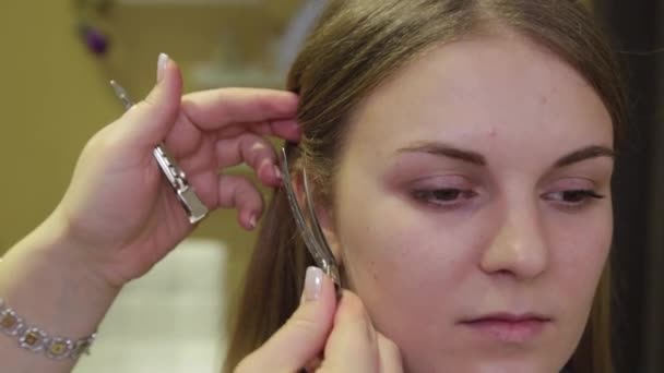 Coiffeur professionnel met une épingle à cheveux sur la tête d'une fille . — Video