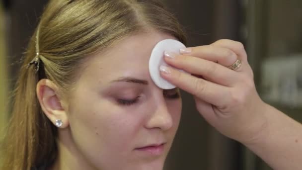 Maquilleur professionnel traite un visage de clients avec un coton-tige . — Video