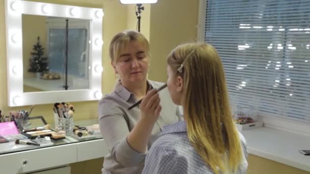 Professionell make-up artist applicerar foundation på ansikte till kund. — Stockvideo