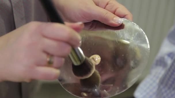 Artista de maquillaje profesional mezcla los cimientos en una paleta . — Vídeos de Stock