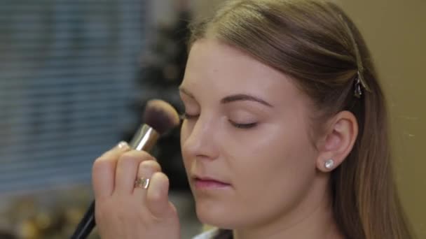 Artista de maquiagem profissional aplica fundação no rosto do cliente . — Vídeo de Stock
