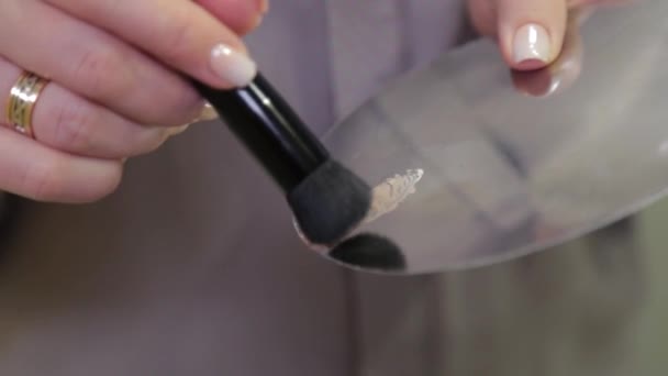 Professionele make-up kunstenaar mixt foundation op een palet. — Stockvideo