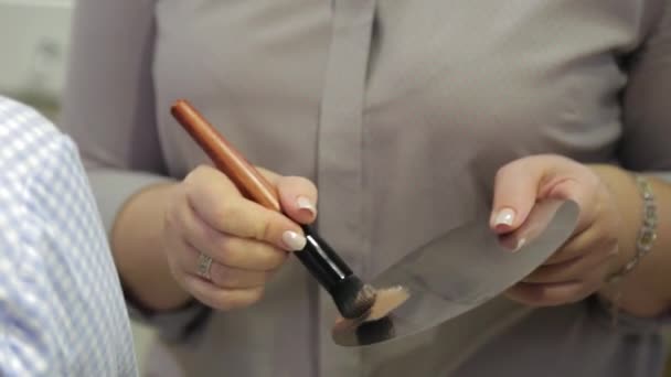Artista de maquiagem profissional mistura fundação em uma paleta . — Vídeo de Stock