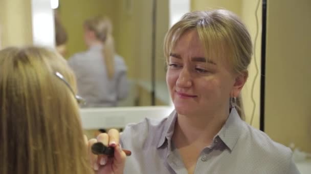 Professional makeup artist applying makeup brush to client. — Stock Video