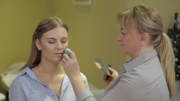 Professionele make-up artiest met een sponsmake-up. — Stockvideo