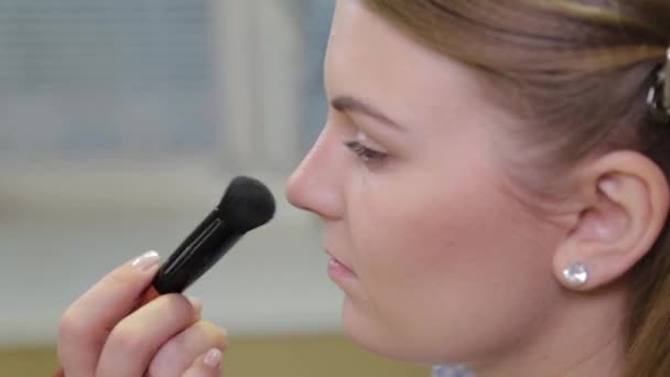 Artista de maquillaje profesional aplicando cepillo de maquillaje al cliente . — Vídeo de stock