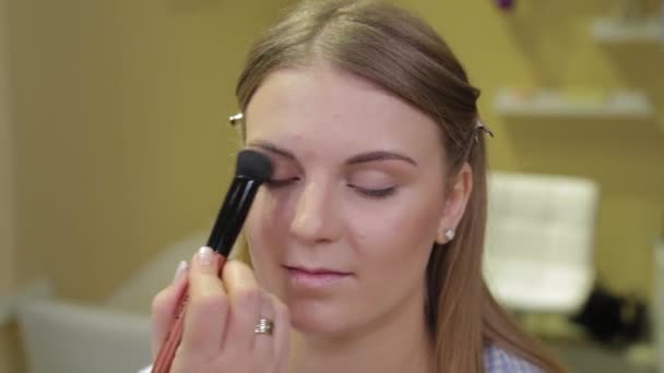 Artista de maquillaje profesional aplicando cepillo de maquillaje al cliente . — Vídeo de stock