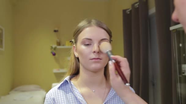 Professionele make-up kunstenaar het aanbrengen van make-up borstel aan de klant. — Stockvideo