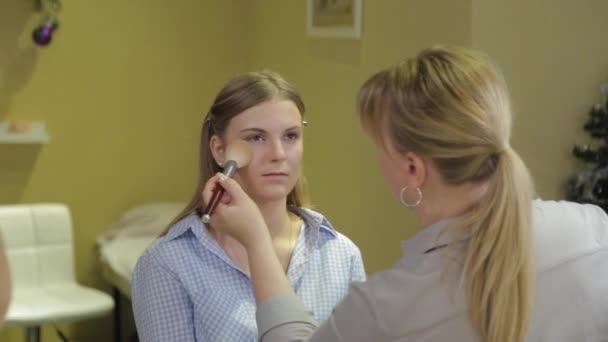 Artista de maquillaje profesional aplicando cepillo de maquillaje al cliente . — Vídeos de Stock