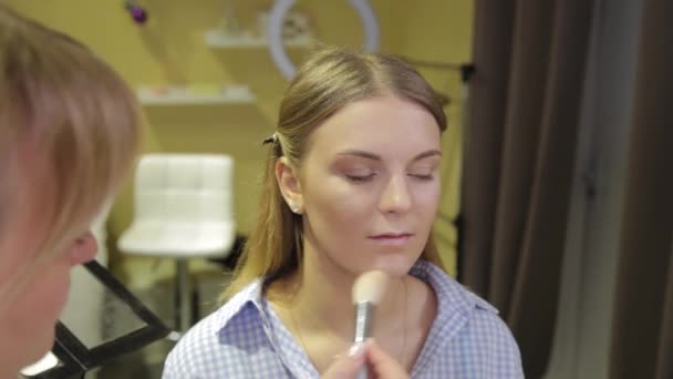 Artista de maquillaje profesional aplicando cepillo de maquillaje al cliente . — Vídeos de Stock