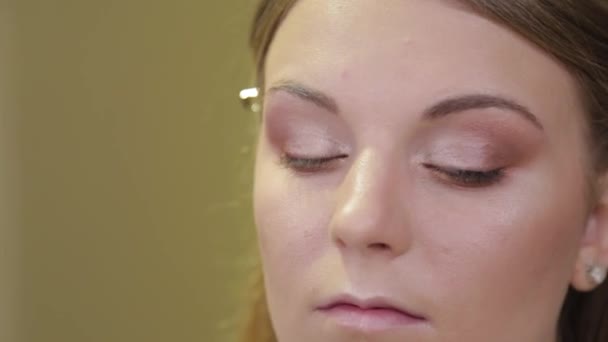 Professionelle Maskenbildnerin malt einem Kunden Wimpern. — Stockvideo