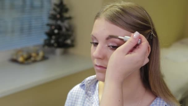 Professionell makeup artist målar ögonbryn till klienten med en speciell borste. — Stockvideo