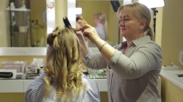 女の子のために夜の髪型を行うプロの美容師. — ストック動画