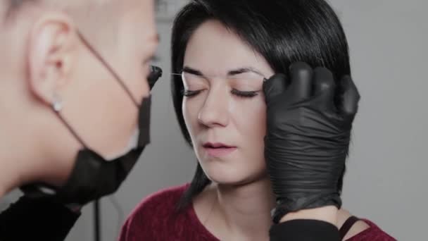 Artistul profesionist de make-up permanent face marcarea sprâncenelor pentru un client . — Videoclip de stoc