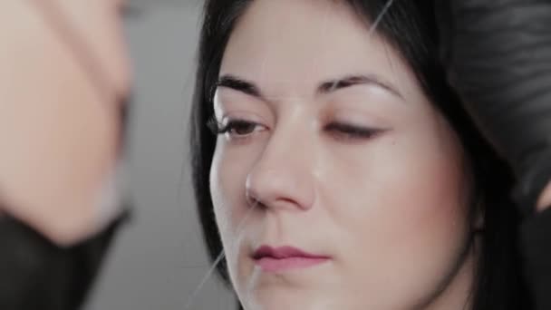 Επαγγελματική μόνιμη make-up καλλιτέχνης κάνει φρύδια σήμανση για έναν πελάτη. — Αρχείο Βίντεο