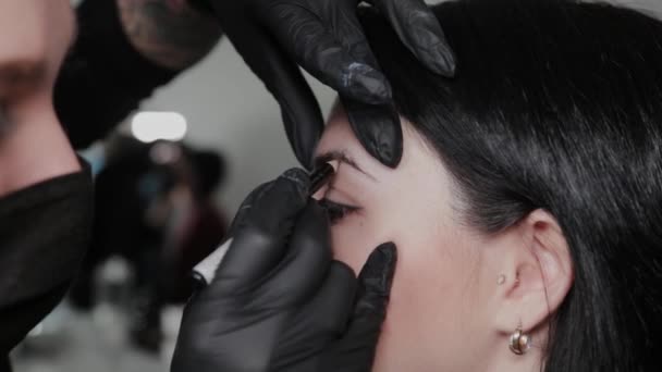 Professional permanent make-up artist does eyebrow marking for a client. — Stock Video