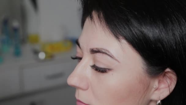 Hermosa mujer en un salón de maquillaje permanente con marcas de cejas . — Vídeo de stock
