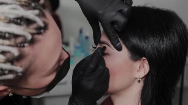 Profesionální permanentní make-up malíř dělá obočí označení pro klienta. — Stock video