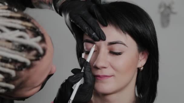 Profesional de maquillaje permanente artista hace marca de cejas para un cliente . — Vídeos de Stock