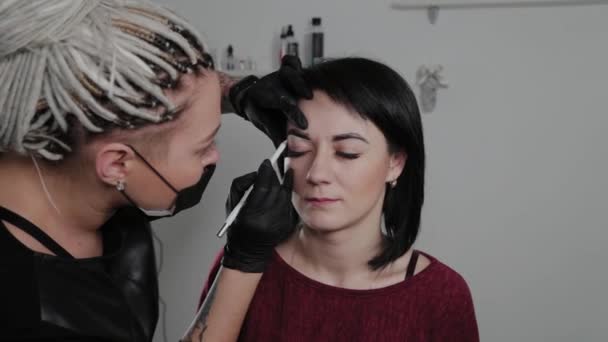 Professionelle Permanent Make-up Artist macht Augenbrauen Markierung für eine Kundin. — Stockvideo