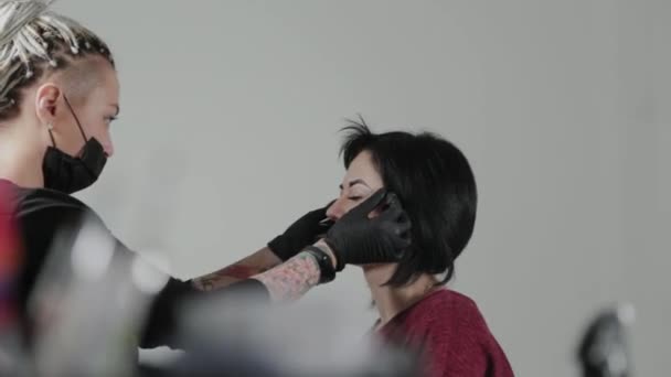 Professionele permanente make-up kunstenaar doet wenkbrauw markering voor een klant. — Stockvideo