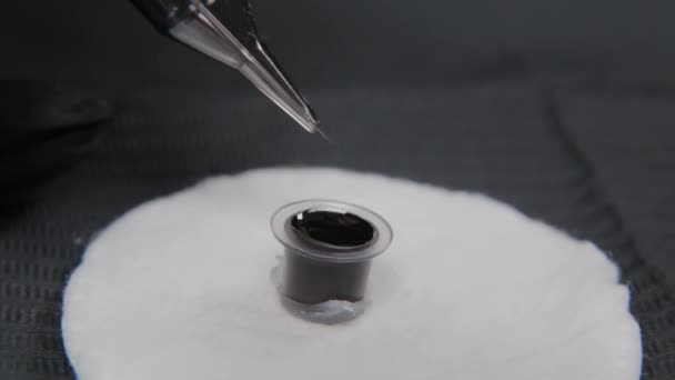 Professional permanent make-up artist draws paint on a tattoo needle. — Stock Video